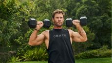 Chris Hemsworth doing overhead press with dumbbells