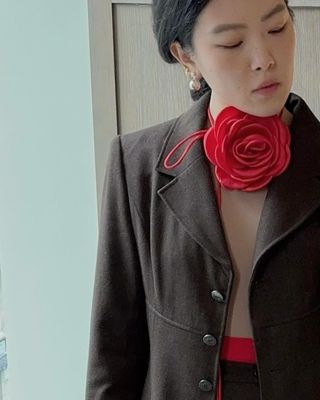 Nordstrom fashion director Linda Zhang takes a mirror selfie with a red rose from the Pico shop around her neck