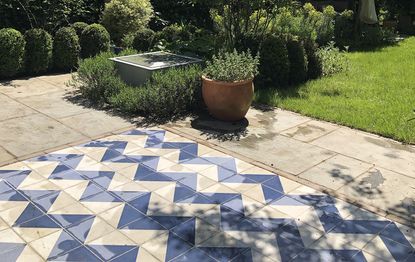 blue and white zig zag patio flooring leading on to a lawn