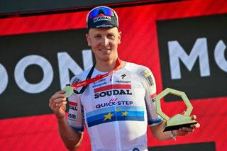 Soudal Quickâ€“Step's Belgian cyclist Tim Merlier celebrates on the podium after winning the sixth stage of the UAE Cycling Tour UCI 2025 in Abu Dhabi on February 22, 2025. (Photo by Giuseppe CACACE / AFP)