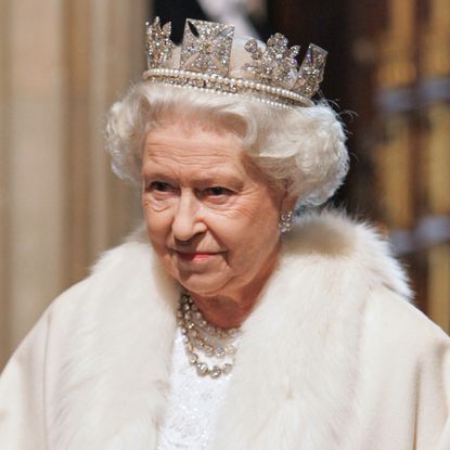 Queen Elizabeth walking her corgis, and wearing a giant crown
