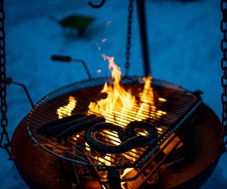 Grilling sausages at night in winter