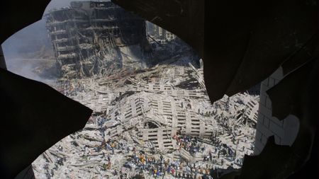 A view of workers at Ground Zero shot through the shattered window of an apartment building on September 13, 2001