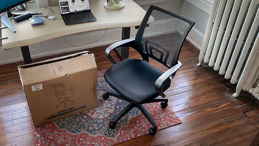 A cheap office chair next to its box in a home office