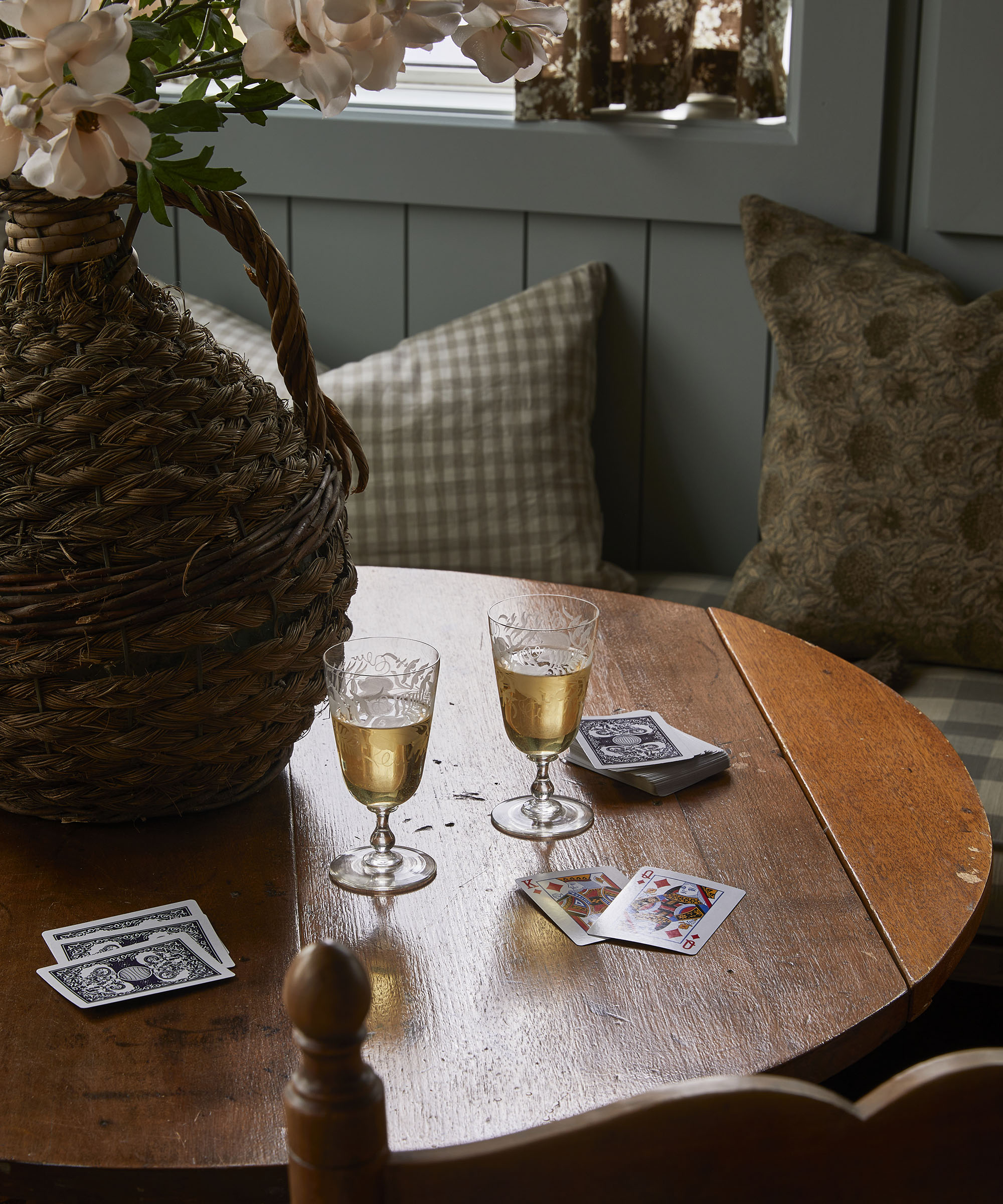 rustic wood table with playing cards on it and glasses of wine