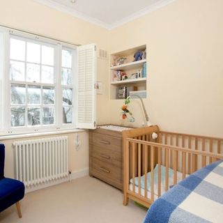 bedroom with wooden cradle and drawer