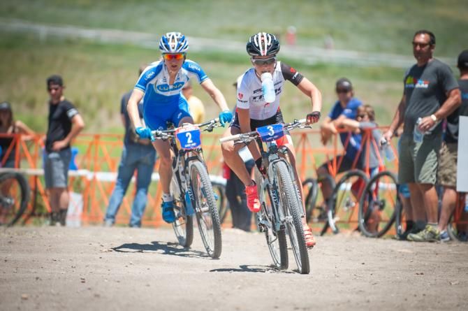 Emily Batty (Trek) takes a handout while Cathrine Pendrel (Luna) sits on her wheel and looks on during the elite women's cross countryrace.