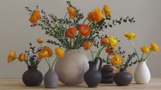 a series of vases with orange ranenculus 