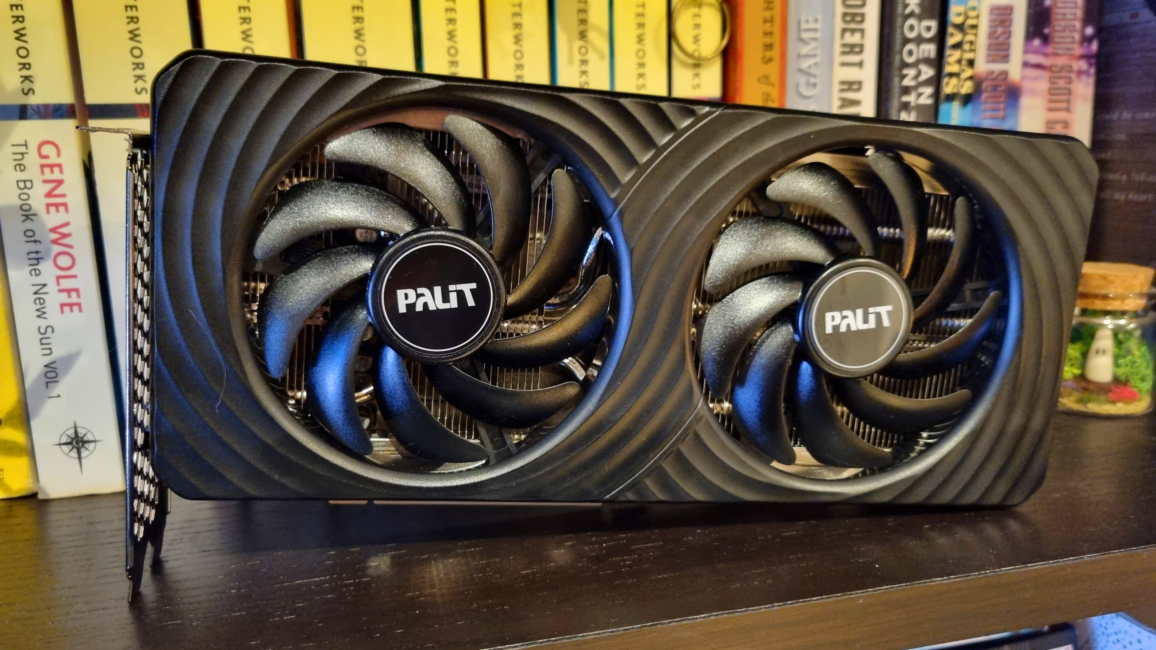 A Palit GeForce RTX 5060 Ti 8 GB Dual in front of some books on a bookshelf