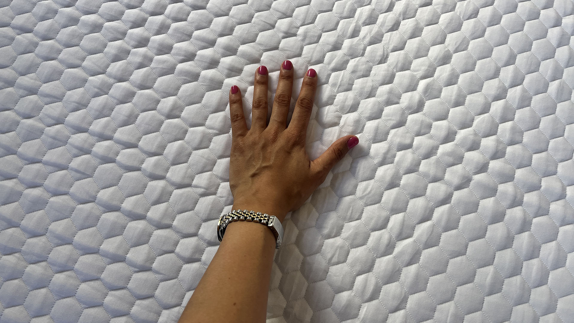 Hand resting on the Layla Essential mattress cover