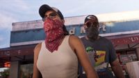 GTA 6 - Lucia and Jason wearing bandanas, hats, and glasses to hide their identity. 