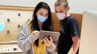 Two people looking at an iPad mini in an Apple Store.