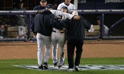 New York Yankee Derek Jeter is carried off of the field by trainer Steve Donohue, right, and manager Joe Girardi after injuring his leg during Game 1 of the American League Championship serie