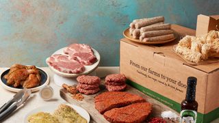 a variety of meat products displayed with a field and flower subscription box