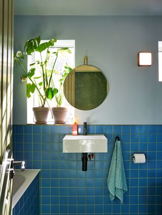 a bathroom with green grout and blue tiles