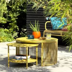 Yellow Ipanema metal garden nesting coffee tables in bright and sunny patio space