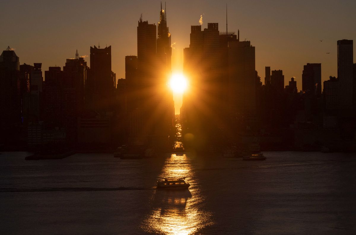 The sun rises above 42nd Street during a reverse &#039;Manhattanhenge&#039; in New York, New York photographed from Weehawken, New Jersey on November 24, 2021. - &#039;Manhattanhenge&#039; is a phenomenon during which the setting sun or the rising sun is aligned with the eastwest streets of the main street grid of Manhattan, New York City