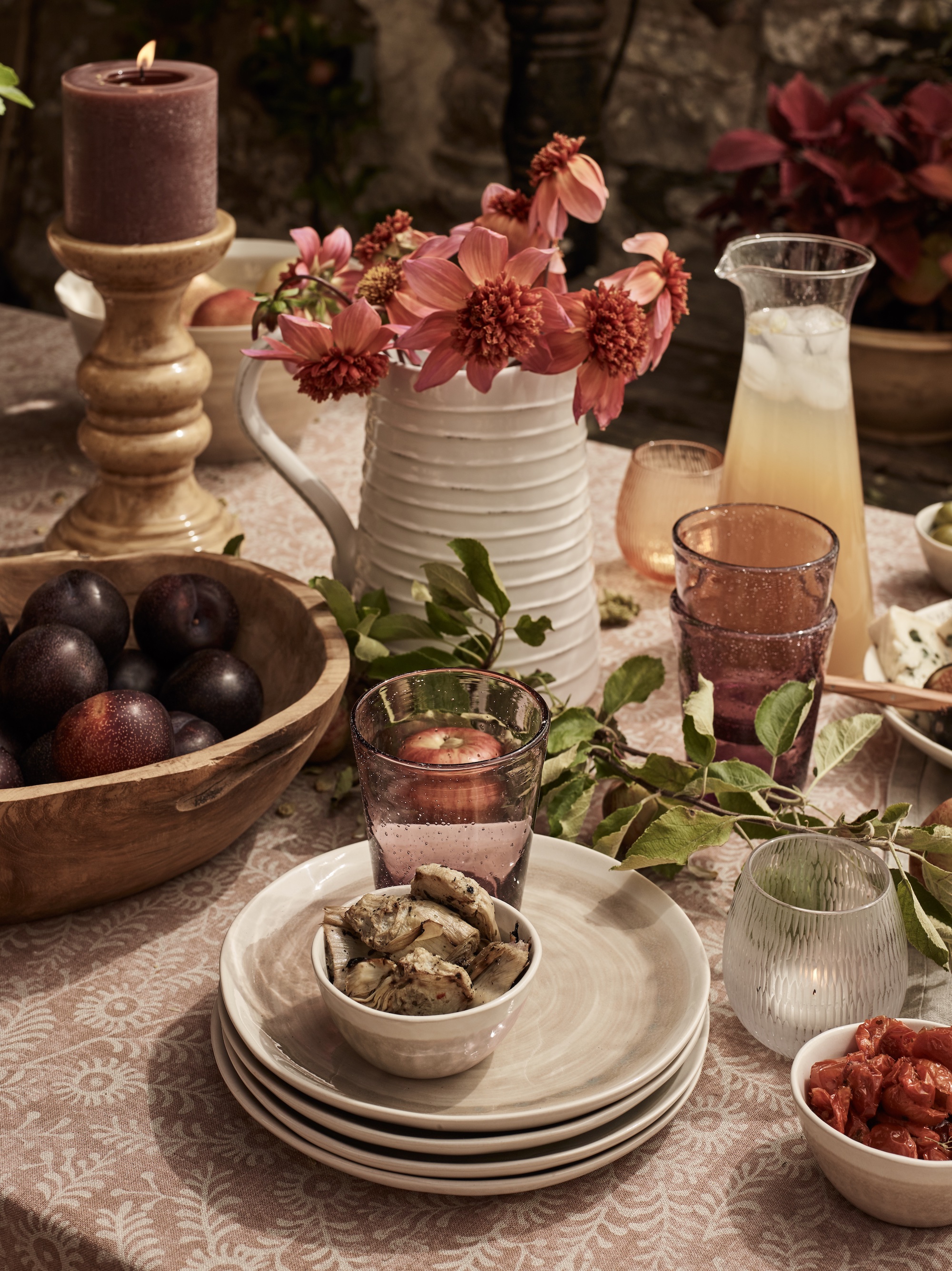fall table idea with ceramic jug and flowers, berry tumblers, wooden bowl, candlestick, off white plates, dusky pink tablecloth