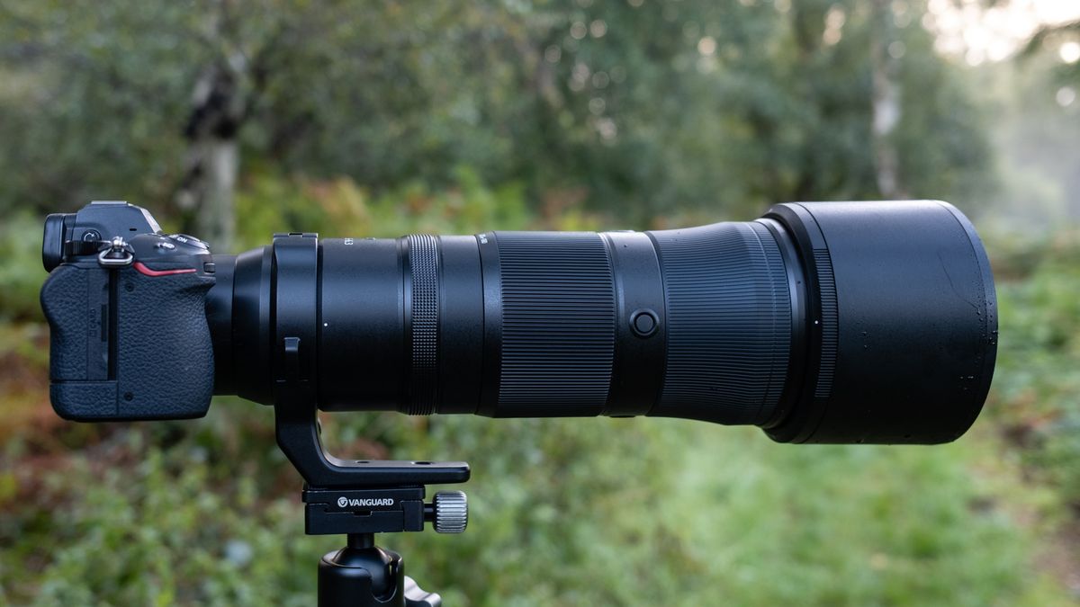Close up photos of the Nikkor Z 180-600mm f/5.6-6.3 VR mounted on a tripod with foliage in the background