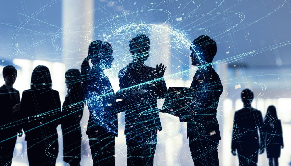 Silhouettes of a team of office workers with a blue technology overlay to represent the future