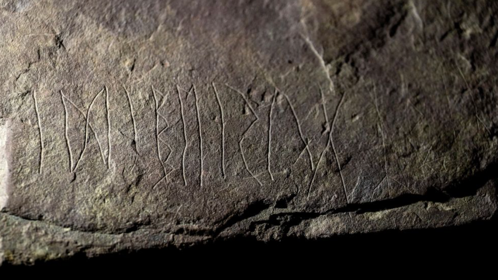 A close-up image of a piece of sandstone with etchings. 