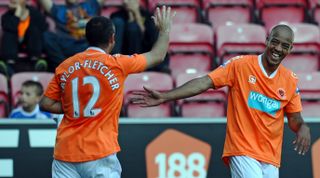Blackpool's English defender Alex Baptiste (R) is congratulated by English striker Gary Taylor-Fletcher as he celebrates scoring their fourth goal during the English Premier League football match between Wigan Athletic and Blackpool at The DW Stadium, Wigan, north-west England on August 14, 2010