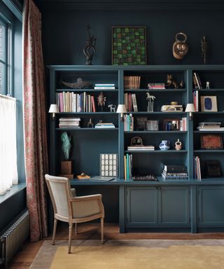 Office with blue walls and bookshelves and chair and rug