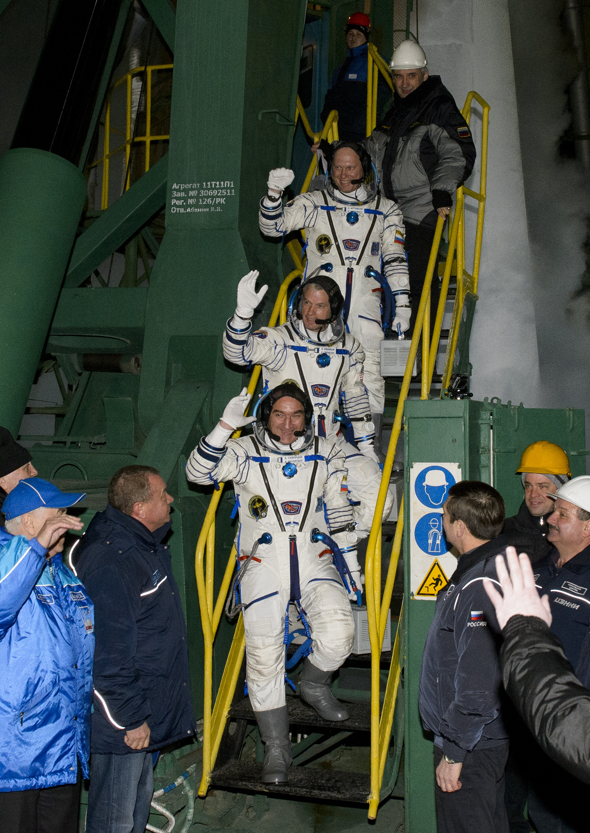 Expedition 39 Soyuz Commander Alexander Skvortsov of the Russian Federal Space Agency, Roscosmos, bottom, Flight Engineer Steve Swanson of NASA, middle, and Flight Engineer Oleg Artemyev of Roscosmos, wave farewell prior to boarding the Soyuz TMA-12M rock