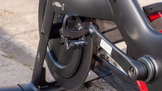 A close up of the crank and pedal on a Peloton Bike +
