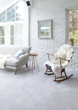 grey carpet in conservatory with exposed brick wall