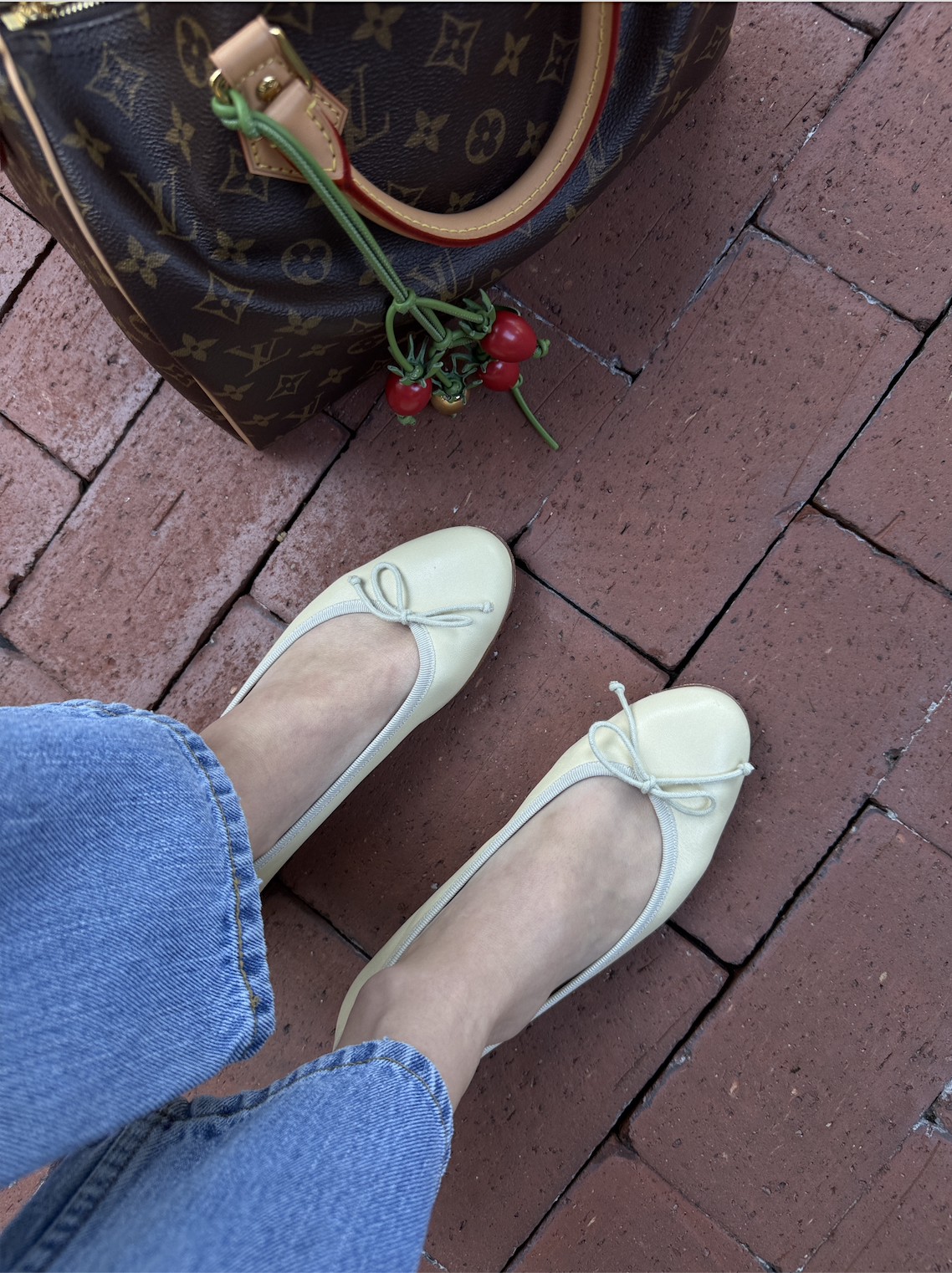 yellow ballet flats on bricks with louis vuitton bag