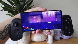 Asus ROG Phone 9 Pro with controller attached and Dead Cells gameplay on screen