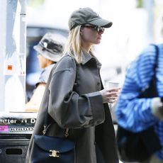 Margot Robbie wears a black bag and trainers.