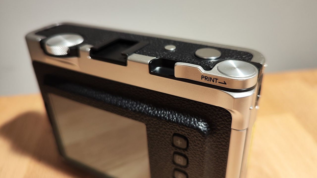 The Fujifilm Instax Mini Evo on a wooden table
