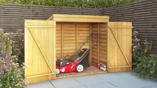 wooden storage shed with doors open and lawnmower inside