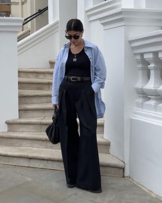 Woman on street wearing vest top, shirt and tailored trousers