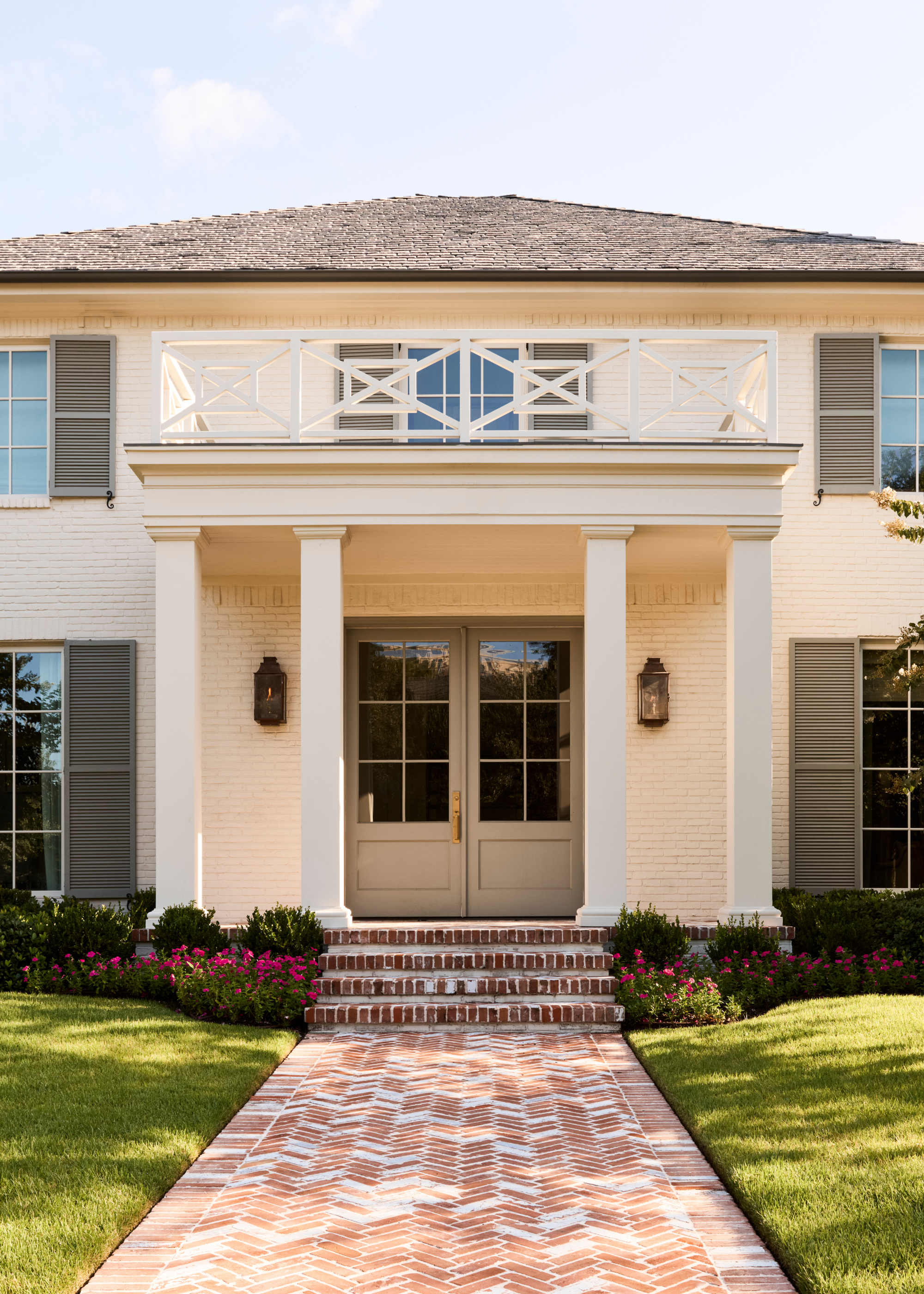 traditional southern home with white bricks and a column-lined entrance