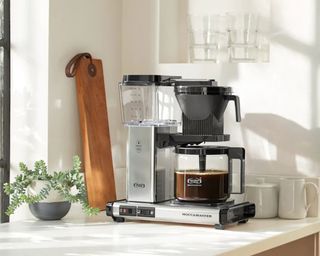 Technivorm Moccamaster coffee maker near window with alcove coffee bar setup