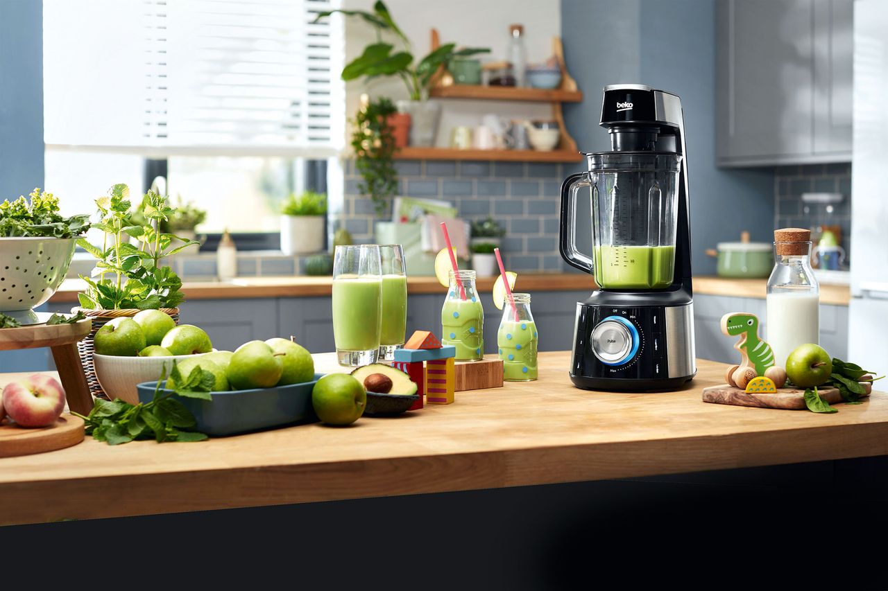 blender on countertop with apples and drinks