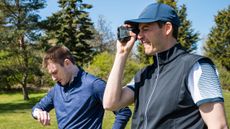 men using gps watch and laser rangefinder