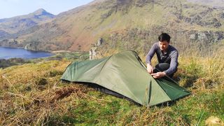 Man setting up Snugpak Ionosphere one-person tent