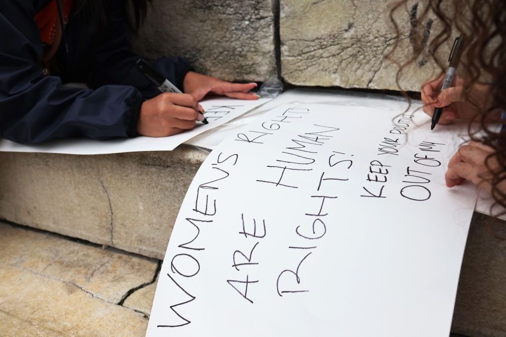 Women write protest signs at a reproductive rights rally