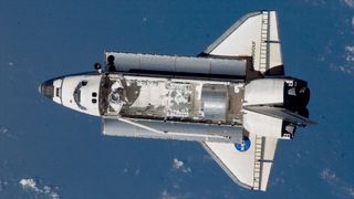 a winged spacecraft is seen approaching a space station with a module and robot in its open cargo bay