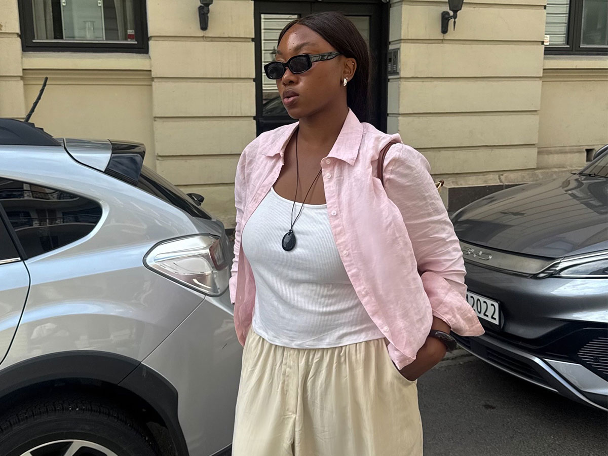 @nnennaechem wearing a pink button-down, white tank, and yellow pants.
