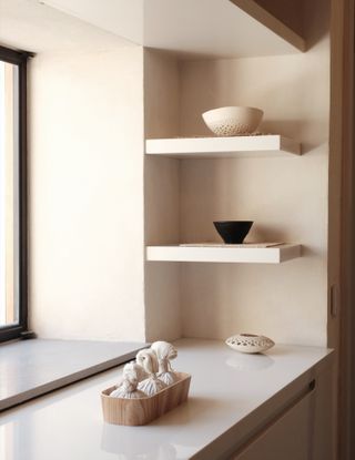 Close up of cupboard and floating shelves in corner of wall