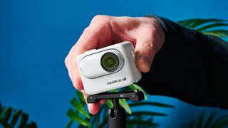 A photo of the Insta360 Go 3S being clipped onto its quick release mount.