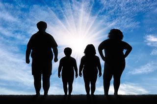 An image of an overweight family, shown in silhouette.