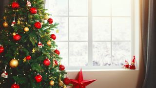 Christmas interior tree with gifts near the window at home