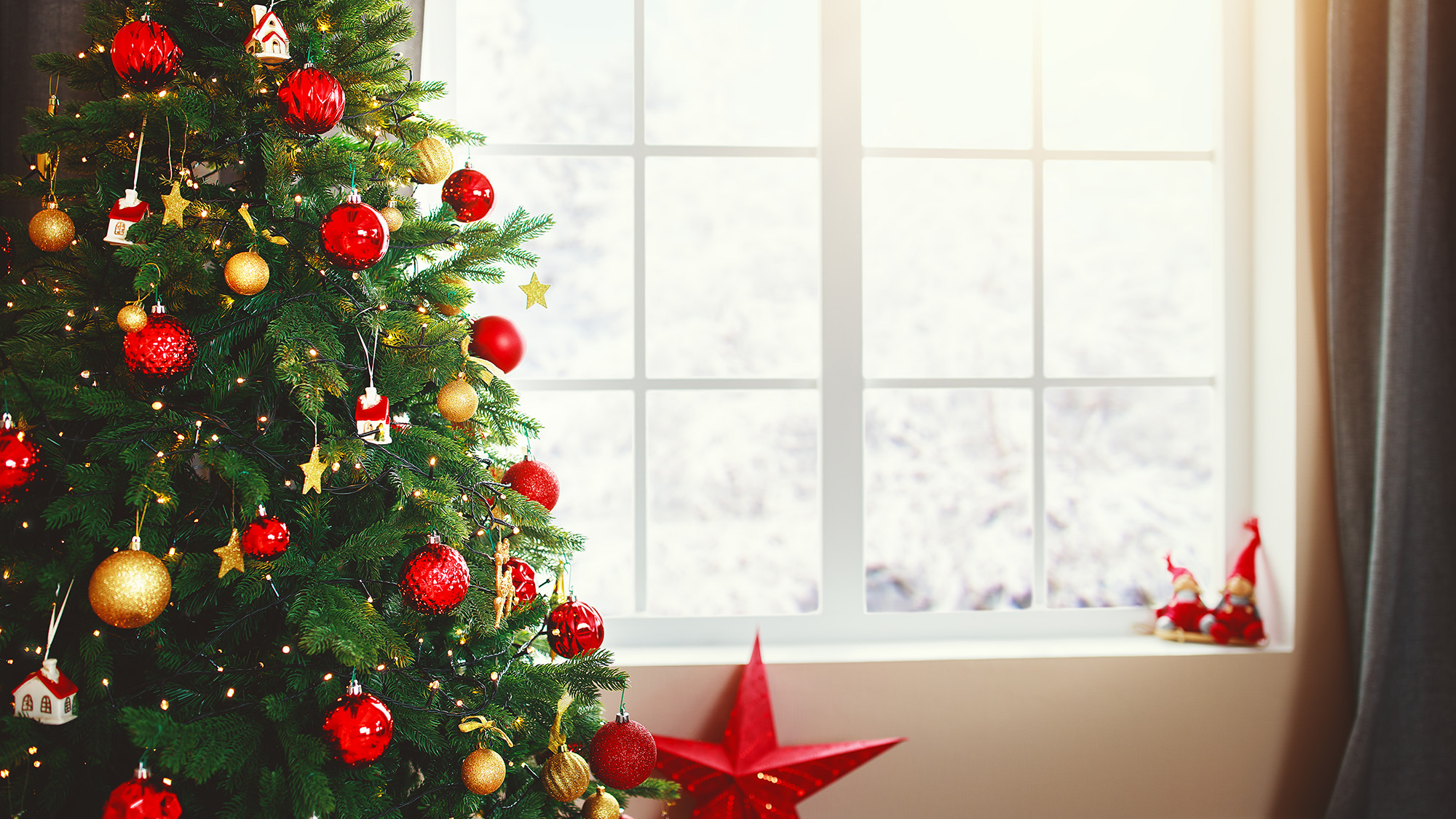 Weihnachtsbaum im Innenbereich mit Geschenken am Fenster zu Hause