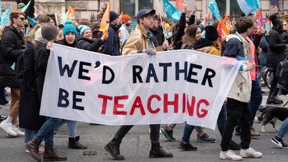 Teachers demonstrating in London. One holds a sign that says ‘We’d rather be teaching’